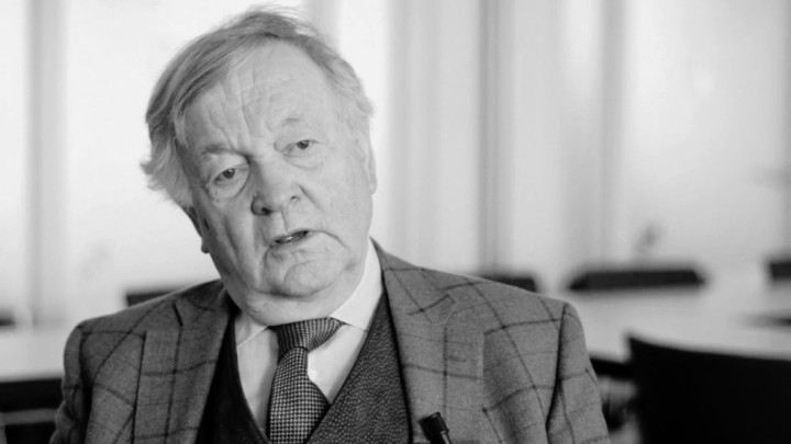 Black and white interview-style headshot photo of Theo van Boven in a conference room or an office